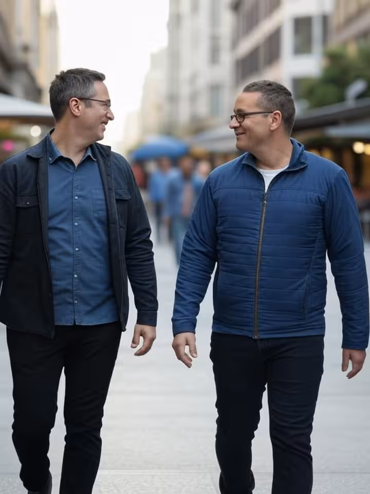 two men walking together through cosmopolitan city street, candid photography, modern urban environm